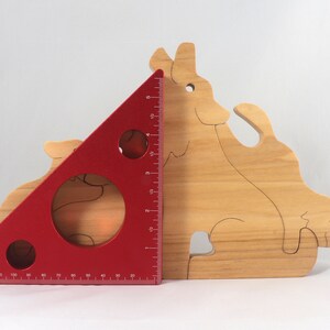 Wooden Wolf Family Stacking Puzzle is handmade from hardwood and finished with mineral oil, beeswax, and carnauba wax. Freestanding interlocking wolf family puzzle pieces shown assembled. Approximate size 10.5 inches long by 6.7 inches high by 3/4 inch thick. Handmade in Tallahassee, Florida, USA.