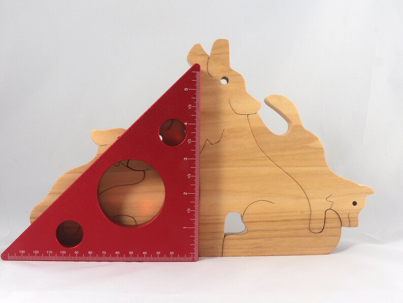 Wooden Wolf Family Stacking Puzzle is handmade from hardwood and finished with mineral oil, beeswax, and carnauba wax. Freestanding interlocking wolf family puzzle pieces shown assembled. Approximate size 10.5 inches long by 6.7 inches high by 3/4 inch thick. Handmade in Tallahassee, Florida, USA.