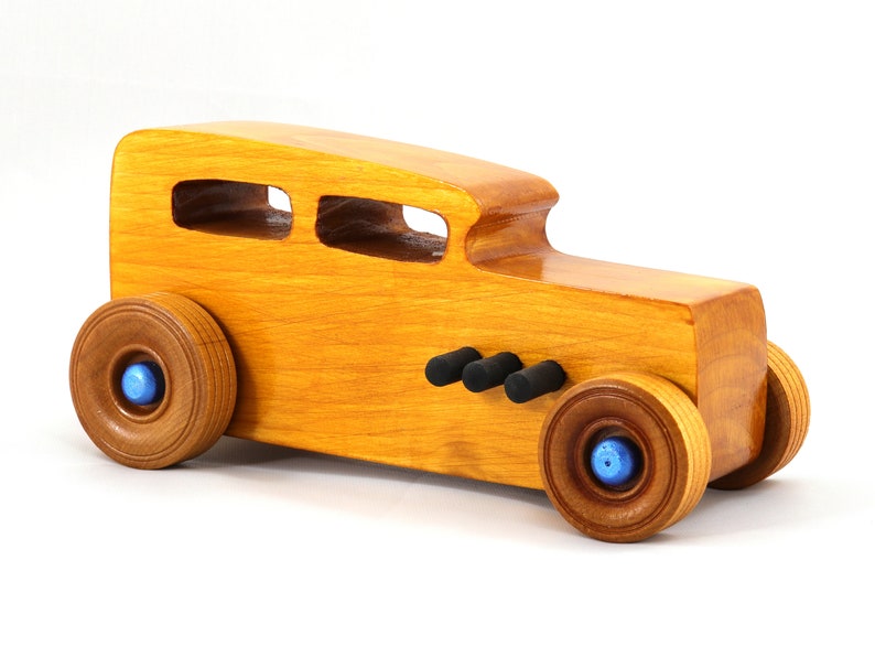 Handcrafted wooden hot rod toy car modeled after a classic '32 sedan. Finished with amber shellac and adorned with metallic sapphire blue and black trim. This unique piece is part of my Hot Rod Collection.