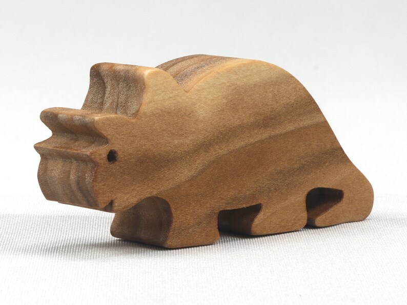 This small wooden triceratops dinosaur toy is crafted from high-quality hardwood and hand-finished. It is a delightful plaything for young children and appeals to many adults.