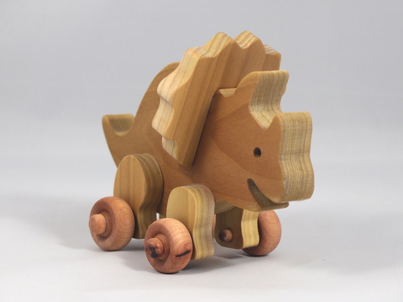 Handmade wooden push toy Triceratops dinosaur made from select grade hardwoods and finished with a non-toxic coating.