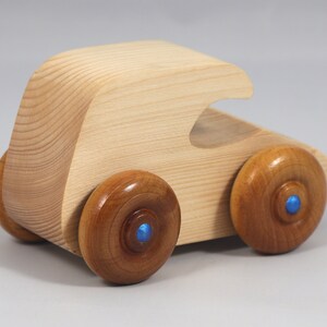 Handmade wooden toy car. The body is finished with clear shellac, and the wheels are finished with amber shellac. The hubs are painted with metallic sapphire blue trim.