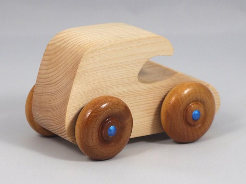 Handmade wooden toy car. The body is finished with clear shellac, and the wheels are finished with amber shellac. The hubs are painted with metallic sapphire blue trim.