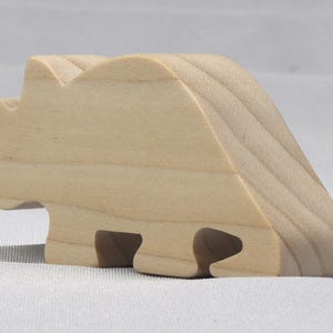 This is an unfinished wooden Wooden Toy Dinosaur Triceratops cutout from solid wood using traditional woodworking techniques. Sanded smooth and ready to paint, stain, or customize. Freestanding design for small hands, toddlers, young children, crafters, collectors, and display. I take custom orders for any animal, quantity, and mix — including large ornament orders. Mix and match, request a different size, or send a drawing or pattern. Handmade by Odin's Toy Factory in Tallahassee, Florida, USA.
