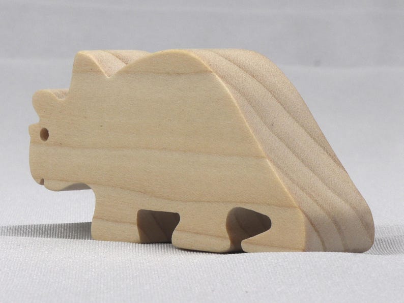 This is an unfinished wooden Wooden Toy Dinosaur Triceratops cutout from solid wood using traditional woodworking techniques. Sanded smooth and ready to paint, stain, or customize. Freestanding design for small hands, toddlers, young children, crafters, collectors, and display. I take custom orders for any animal, quantity, and mix — including large ornament orders. Mix and match, request a different size, or send a drawing or pattern. Handmade by Odin's Toy Factory in Tallahassee, Florida, USA.