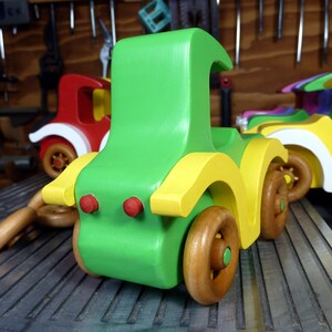 Handmade wooden toy car, vintage-style Model T sedan, painted bright green and yellow with spoked wheels, finished in amber shellac.  Handcrafted in Tallahassee, Florida, USA by Odin's Toy Factory.