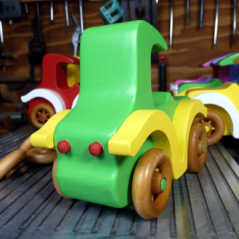 Handmade wooden toy car, vintage-style Model T sedan, painted bright green and yellow with spoked wheels, finished in amber shellac.  Handcrafted in Tallahassee, Florida, USA by Odin's Toy Factory.