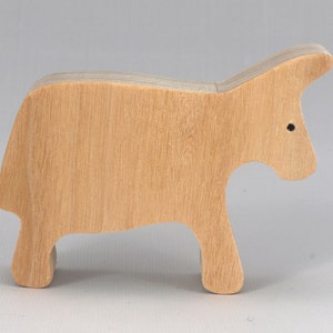 A handmade and unfinished wooden toy cow cutout is perfect for those who love to paint and customize their toys. It is freestanding and stackable, making it a versatile addition to any playroom or nursery. From My Itty Bitty Animal Collection.