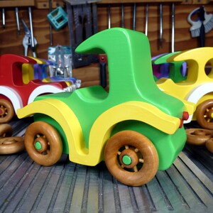 Handmade wooden toy car, vintage-style Model T sedan, painted bright green and yellow with spoked wheels, finished in amber shellac.  Handcrafted in Tallahassee, Florida, USA by Odin's Toy Factory.