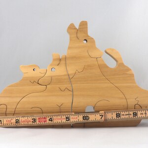 Wooden Wolf Family Stacking Puzzle is handmade from hardwood and finished with mineral oil, beeswax, and carnauba wax. Freestanding interlocking wolf family puzzle pieces shown assembled. Approximate size 10.5 inches long by 6.7 inches high by 3/4 inch thick. Handmade in Tallahassee, Florida, USA.