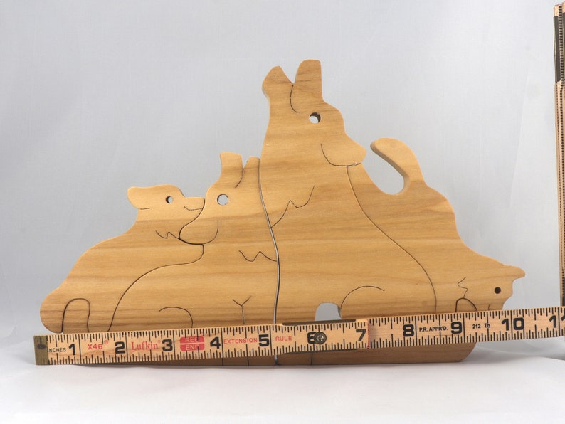 Wooden Wolf Family Stacking Puzzle is handmade from hardwood and finished with mineral oil, beeswax, and carnauba wax. Freestanding interlocking wolf family puzzle pieces shown assembled. Approximate size 10.5 inches long by 6.7 inches high by 3/4 inch thick. Handmade in Tallahassee, Florida, USA.
