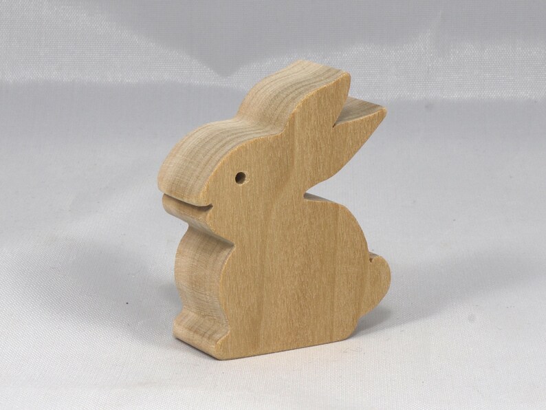 This is an unfinished wooden Rabbit cutout from solid wood using traditional woodworking techniques. Sanded smooth and ready to paint, stain, or customize. Freestanding design for small hands, toddlers, young children, crafters, collectors, and display. I take custom orders for any animal, quantity, and mix — including large ornament orders. Mix and match, request a different size, or send a drawing or pattern. Handmade by Odin's Toy Factory in Tallahassee, Florida, USA.