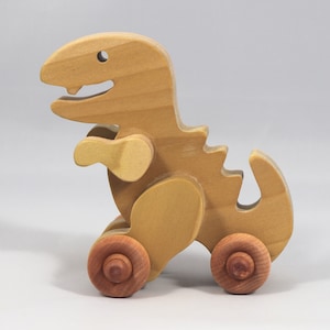 Handmade wooden push toy Tyrannosaurus Rex dinosaur made from select grade hardwoods and finished with a non-toxic coating.