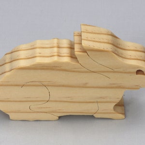 This is an unfinished wooden Rabbit cutout from solid wood using traditional woodworking techniques. Sanded smooth and ready to paint, stain, or customize. Freestanding design for small hands, toddlers, young children, crafters, collectors, and display. I take custom orders for any animal, quantity, and mix — including large ornament orders. Mix and match, request a different size, or send a drawing or pattern. Handmade by Odin's Toy Factory in Tallahassee, Florida, USA.