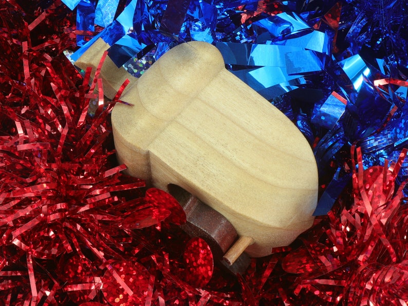 Handmade wooden miniature birdhouse ornament cut from wood with rounded edges, natural wood grain and color variations, finished with non-toxic shellac or food-safe oils and beeswax, lightweight and ready to hang. Made in Tallahassee, Florida, USA, by Odin's Toy Factory.