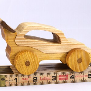 Handmade wooden toy car finished with nontoxic clear amber shellac and contrasting wood trim. Part of the Speedy Wheels Collection. Handcrafted in Tallahassee, Florida, USA. Length 5-1/2 inches, width 2-1/2 inches, height 2-1/2 inches. Made at Odin's Toy Factory.