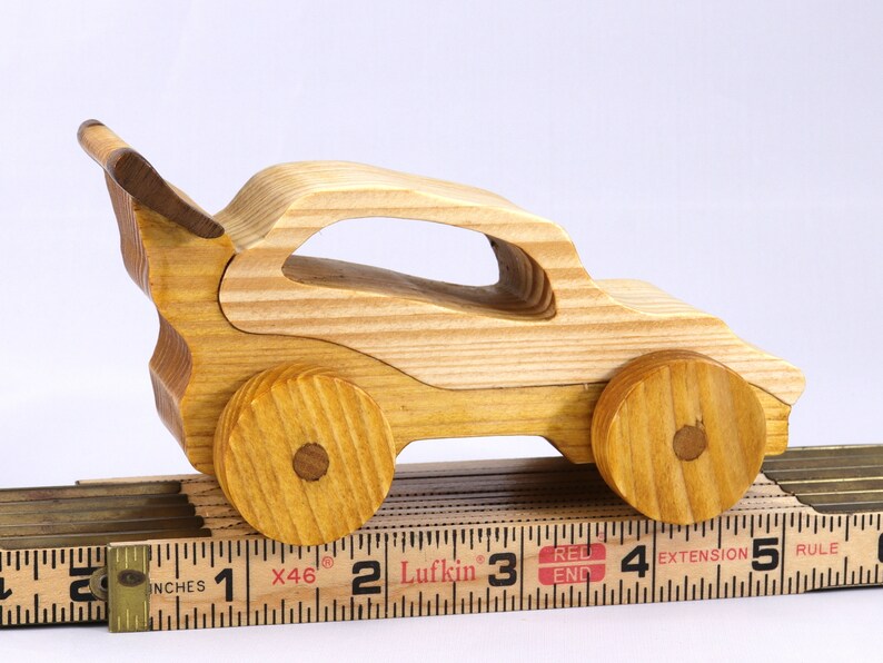 Handmade wooden toy car finished with nontoxic clear amber shellac and contrasting wood trim. Part of the Speedy Wheels Collection. Handcrafted in Tallahassee, Florida, USA. Length 5-1/2 inches, width 2-1/2 inches, height 2-1/2 inches. Made at Odin's Toy Factory.