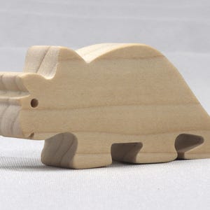 This is an unfinished wooden Wooden Toy Dinosaur Triceratops cutout from solid wood using traditional woodworking techniques. Sanded smooth and ready to paint, stain, or customize. Freestanding design for small hands, toddlers, young children, crafters, collectors, and display. I take custom orders for any animal, quantity, and mix — including large ornament orders. Mix and match, request a different size, or send a drawing or pattern. Handmade by Odin's Toy Factory in Tallahassee, Florida, USA.