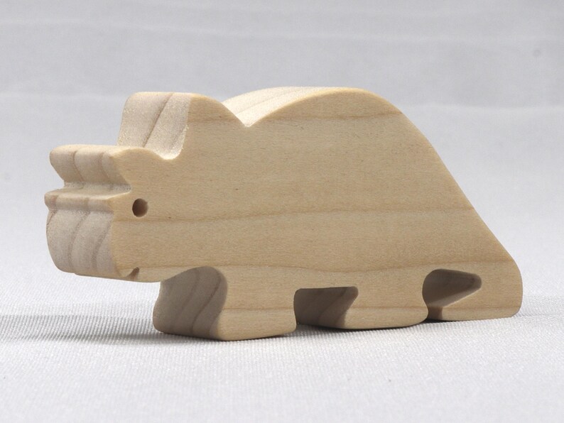 This is an unfinished wooden Wooden Toy Dinosaur Triceratops cutout from solid wood using traditional woodworking techniques. Sanded smooth and ready to paint, stain, or customize. Freestanding design for small hands, toddlers, young children, crafters, collectors, and display. I take custom orders for any animal, quantity, and mix — including large ornament orders. Mix and match, request a different size, or send a drawing or pattern. Handmade by Odin's Toy Factory in Tallahassee, Florida, USA.