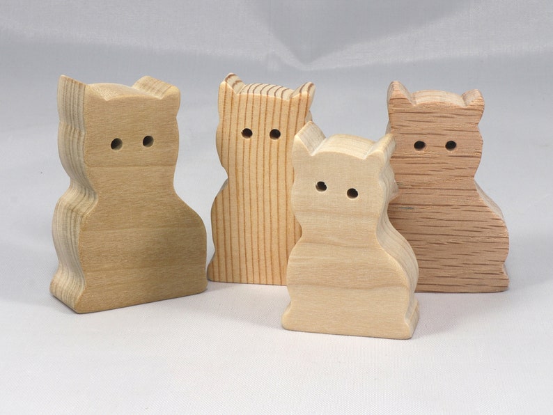 A handmade freestanding wooden toy cat cutout 1/2-3/4 inches thick is made from various kinds of wood sanded smooth and ready to paint. It is excellent for kids' crafts, pretend, or stacking toys. Other sizes are available with a custom order.