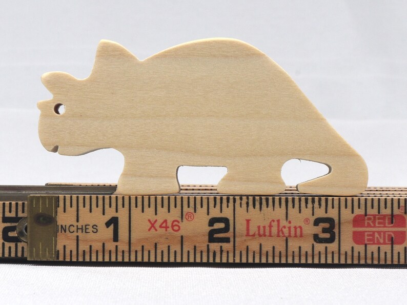 This is an unfinished wooden Wooden Toy Dinosaur Triceratops cutout from solid wood using traditional woodworking techniques. Sanded smooth and ready to paint, stain, or customize. Freestanding design for small hands, toddlers, young children, crafters, collectors, and display. I take custom orders for any animal, quantity, and mix — including large ornament orders. Mix and match, request a different size, or send a drawing or pattern. Handmade by Odin's Toy Factory in Tallahassee, Florida, USA.