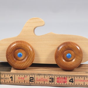 Handmade wooden toy car. The body is finished with clear shellac, and the wheels are finished with amber shellac. The hubs are painted with metallic sapphire blue trim.