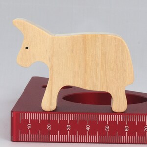 A handmade and unfinished wooden toy cow cutout is perfect for those who love to paint and customize their toys. It is freestanding and stackable, making it a versatile addition to any playroom or nursery. From My Itty Bitty Animal Collection.
