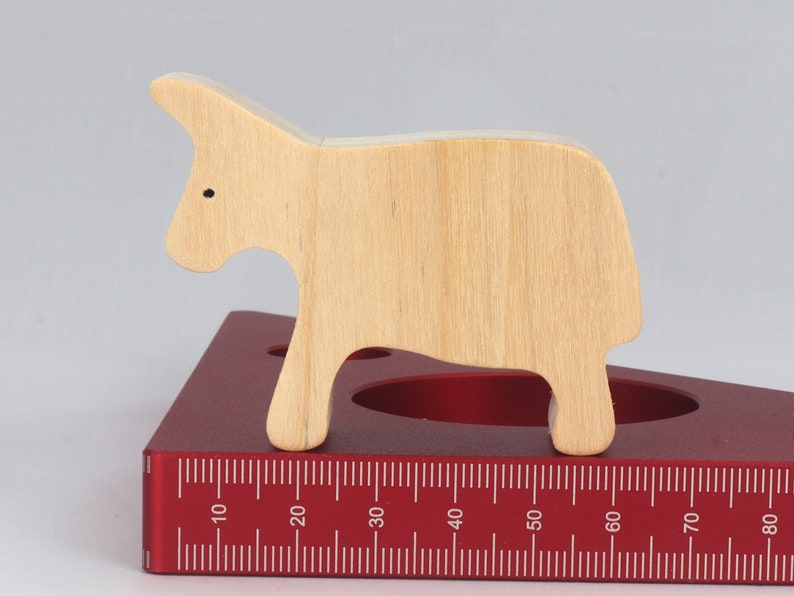 A handmade and unfinished wooden toy cow cutout is perfect for those who love to paint and customize their toys. It is freestanding and stackable, making it a versatile addition to any playroom or nursery. From My Itty Bitty Animal Collection.