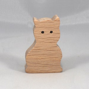 A handmade freestanding wooden toy cat cutout 1/2-3/4 inches thick is made from various kinds of wood sanded smooth and ready to paint. It is excellent for kids' crafts, pretend, or stacking toys. Other sizes are available with a custom order.