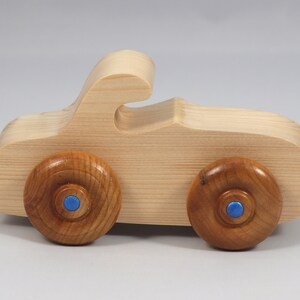 Handmade wooden toy car. The body is finished with clear shellac, and the wheels are finished with amber shellac. The hubs are painted with metallic sapphire blue trim.