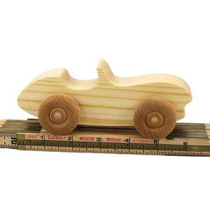 A small, handcrafted wooden toy convertible sports car, finished with a custom blend of oils and waxes, is the perfect gift for young children.