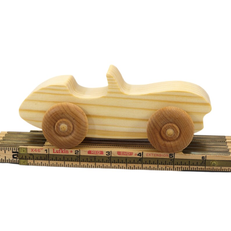 A small, handcrafted wooden toy convertible sports car, finished with a custom blend of oils and waxes, is the perfect gift for young children.