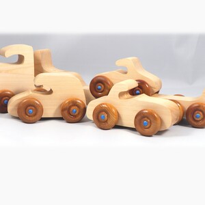 Handmade wooden toy truck play set includes three cars and a tractor-trailer finished with clear and amber shellac with metallic sapphire blue trim.