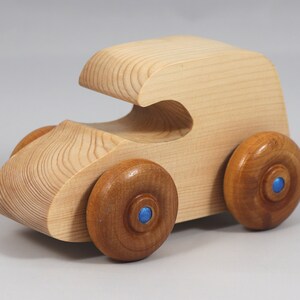 Handmade wooden toy car. The body is finished with clear shellac, and the wheels are finished with amber shellac. The hubs are painted with metallic sapphire blue trim.