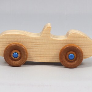 Handmade wooden toy car convertible sports coupe with a nontoxic satin polyethylene finish, amber shellac wheels, and metallic sapphire blue trim.
