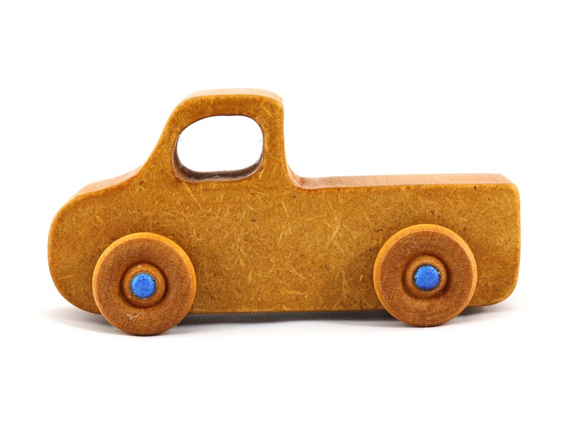 This handmade toy pickup truck from My Play Pal Collection is finished with amber shellac and metallic sapphire blue acrylic paint. It is just one of many unique wooden vehicles available.