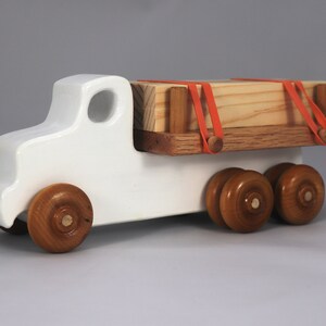 Handmade wooden toy lumber truck from Odin's Toy Factory Easy 5 Truck Fleet Collection. Painted lumber truck with acrylic body, shellac bed, and wheels. Measures approximately 9 inches long, 4 inches high, and 3.5 inches wide. Handmade in Tallahassee, Florida, USA. Custom colors available.