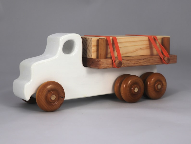 Handmade wooden toy lumber truck from Odin's Toy Factory Easy 5 Truck Fleet Collection. Painted lumber truck with acrylic body, shellac bed, and wheels. Measures approximately 9 inches long, 4 inches high, and 3.5 inches wide. Handmade in Tallahassee, Florida, USA. Custom colors available.