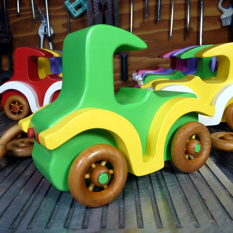 Handmade wooden toy car, vintage-style Model T sedan, painted bright green and yellow with spoked wheels, finished in amber shellac.  Handcrafted in Tallahassee, Florida, USA by Odin's Toy Factory.