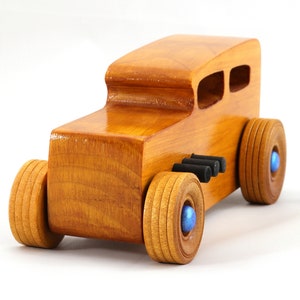 Handcrafted wooden hot rod toy car modeled after a classic '32 sedan. Finished with amber shellac and adorned with metallic sapphire blue and black trim. This unique piece is part of my Hot Rod Collection.