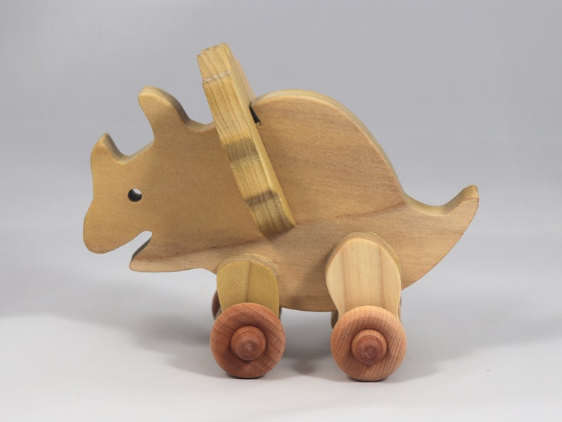 Handmade wooden push toy Triceratops dinosaur made from select grade hardwoods and finished with a non-toxic coating.