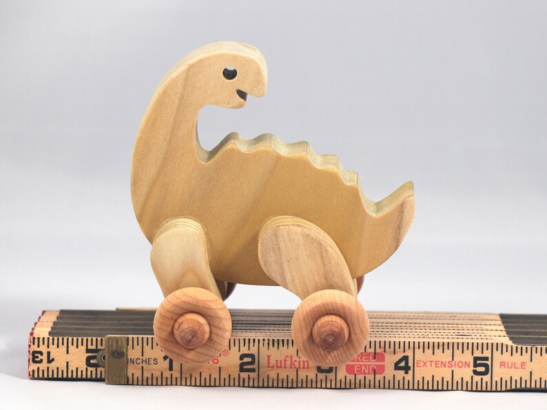 Handmade wooden push toy dinosaur made from select grade hardwoods and finished with a non-toxic coating.
