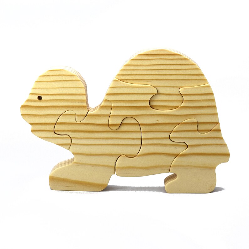 Handmade wooden turtle puzzle with 5 simple interlocking pieces. Freestanding 5-piece wooden puzzle. Approximate dimensions: 5 inches high by 7.25 inches long by 0.75 inches thick. Finished with mineral oil and beeswax blend. Handcrafted in Tallahassee, Florida, USA, using natural wood. Unique wood grain color and knot variations. Odin’s Toy Factory.