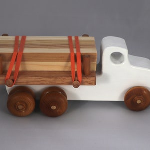 Handmade wooden toy lumber truck from Odin's Toy Factory Easy 5 Truck Fleet Collection. Painted lumber truck with acrylic body, shellac bed, and wheels. Measures approximately 9 inches long, 4 inches high, and 3.5 inches wide. Handmade in Tallahassee, Florida, USA. Custom colors available.