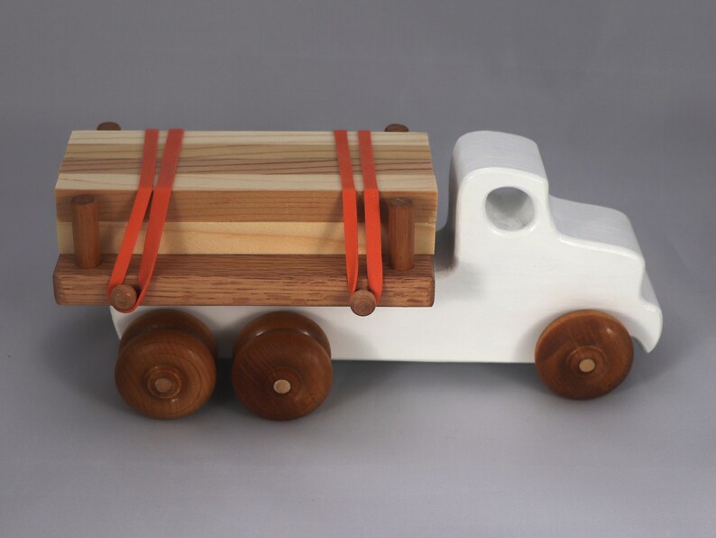 Handmade wooden toy lumber truck from Odin's Toy Factory Easy 5 Truck Fleet Collection. Painted lumber truck with acrylic body, shellac bed, and wheels. Measures approximately 9 inches long, 4 inches high, and 3.5 inches wide. Handmade in Tallahassee, Florida, USA. Custom colors available.