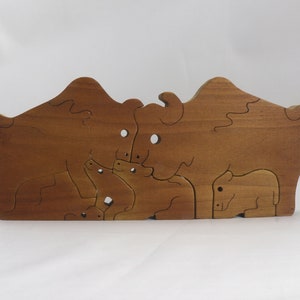Wooden 6-piece bison family puzzle with two adult bison and four calves. The hardwood pieces interlock into one standing group or separate to stand alone. Handnmade in Tallahassee, Florida, USA by Odin's Toy Factory.