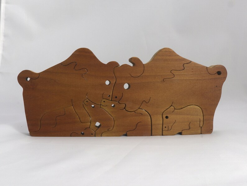 Wooden 6-piece bison family puzzle with two adult bison and four calves. The hardwood pieces interlock into one standing group or separate to stand alone. Handnmade in Tallahassee, Florida, USA by Odin's Toy Factory.