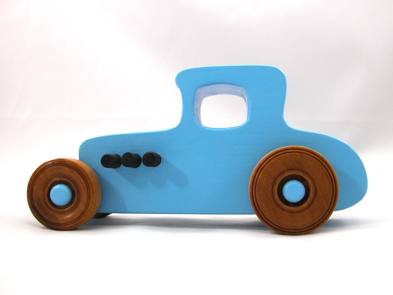 Handmade wooden toy car modeled after a '27 T-Coupe, finished with baby blue and black acrylic paint with nonmarring amber shellac wheels from my hot rod collection.