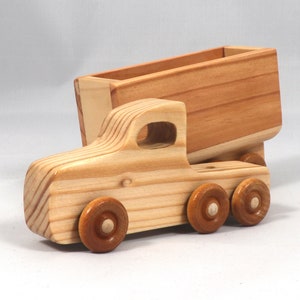 Handmade wooden toy tractor trailer semi truck finished with clear shellac. Crafted from natural wood using traditional woodworking tools. Approximate size 7 inches long. Made in Tallahassee, Florida, USA from Odin's Toy Factory Play Pal Collection.