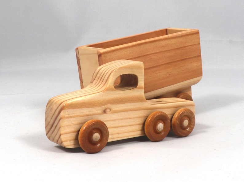 Handmade wooden toy tractor trailer semi truck finished with clear shellac. Crafted from natural wood using traditional woodworking tools. Approximate size 7 inches long. Made in Tallahassee, Florida, USA from Odin's Toy Factory Play Pal Collection.